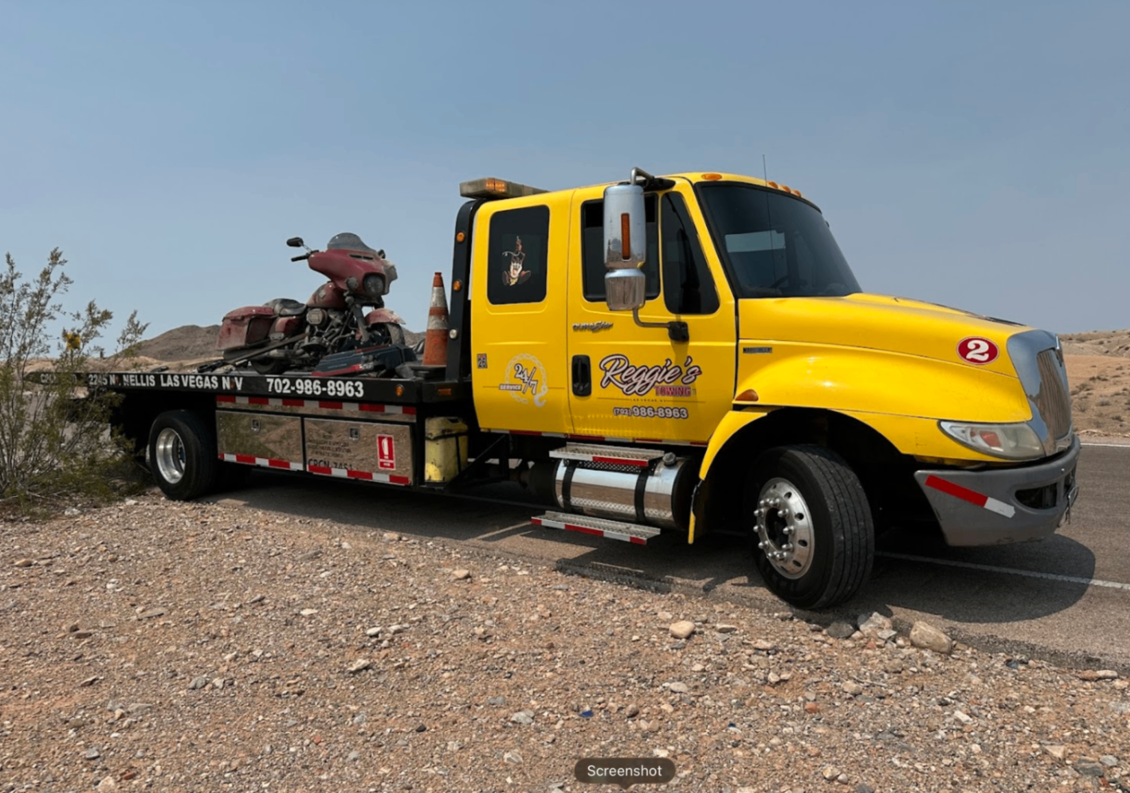 Yellow Reggie's Towing flatbed with Harley-Davidson motorcycle