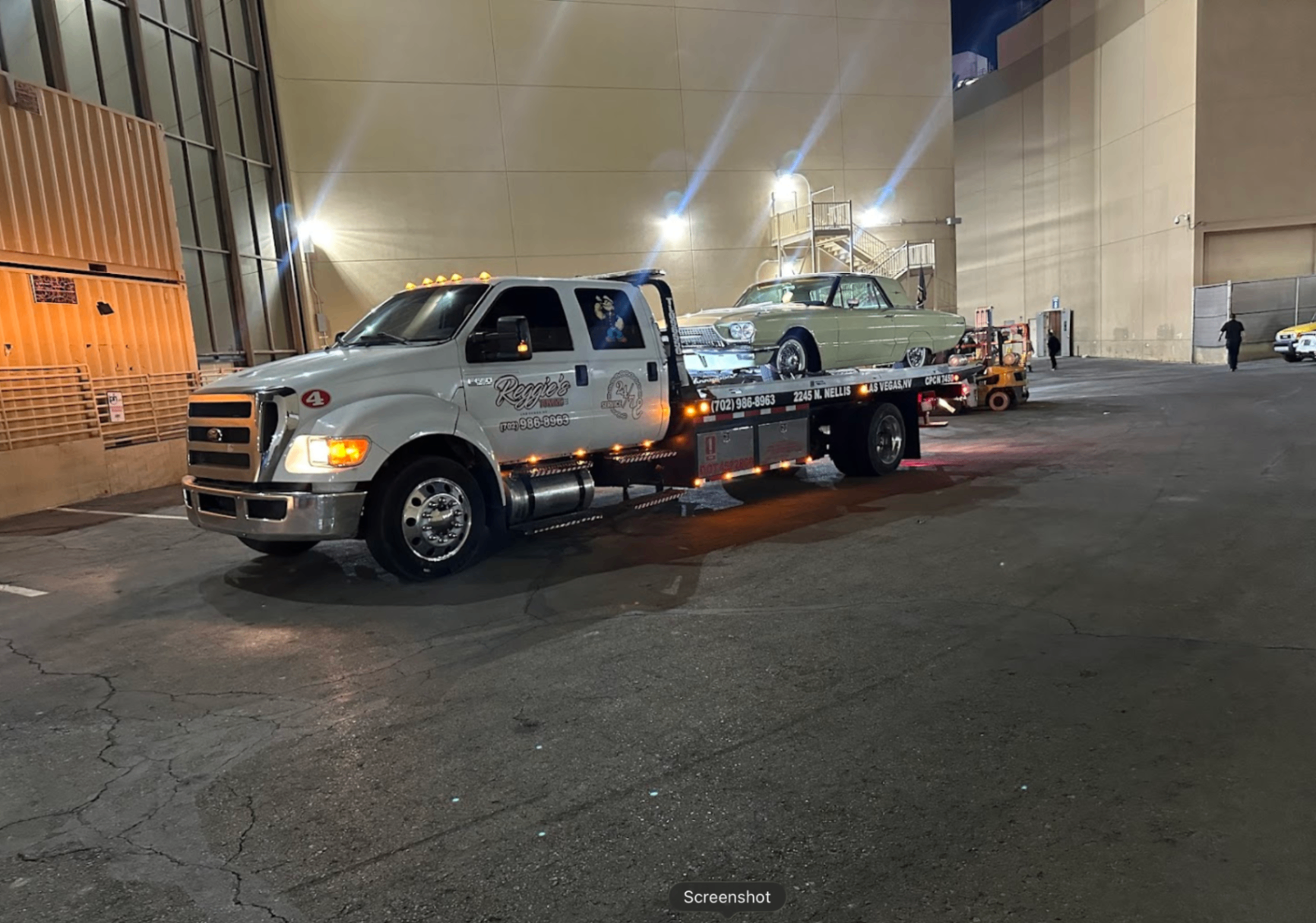 Reggie's Towing flatbed with vintage Ford Thunderbird at night